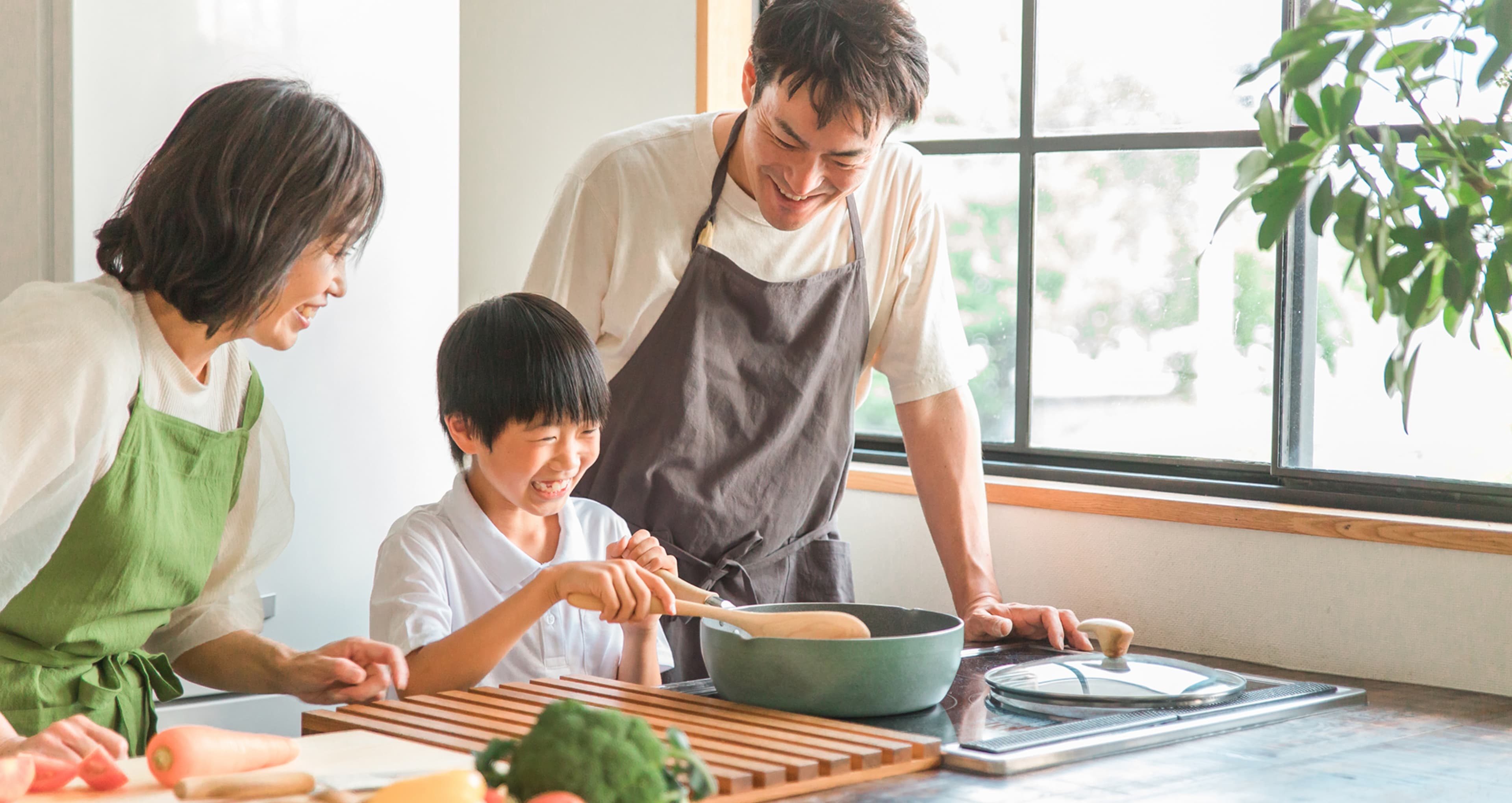 父、母、子供が一緒に調理を楽しむ様子